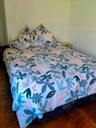 阿洛菲Kaina Kaute的卧室内的一张床铺,配有花卉床罩