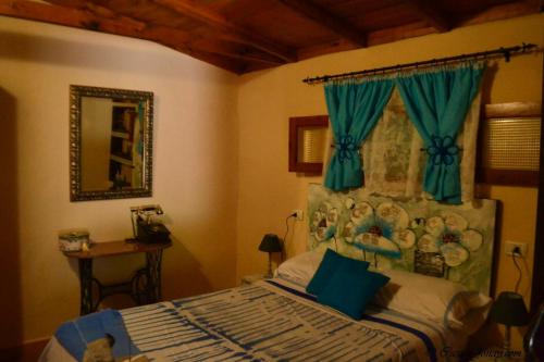 埃尔米瓜One bedroom chalet with terrace and wifi at Hermigua 3 km away from the beach的一间卧室配有一张蓝色窗帘的床