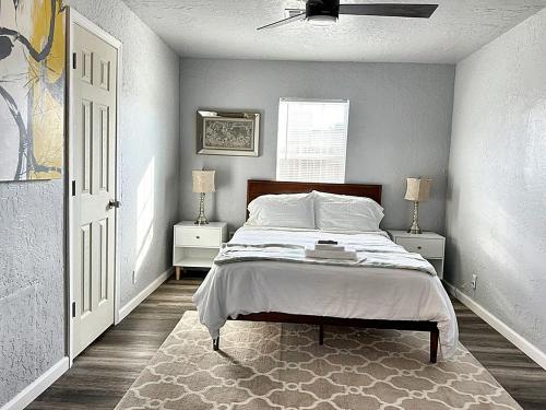俄克拉何马城Spring Break Retreat Studio Rainfall Shower的一间卧室配有一张带2个床头柜和2盏灯的床。