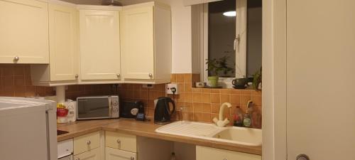 South NorwoodCroydon Homestay-Shared Apartment with Shared Bathroom的厨房配有白色橱柜和水槽