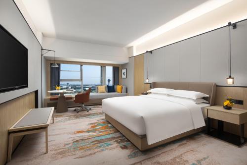 长沙voco 长沙机场voco酒店的一间带白色大床的卧室和一间客厅