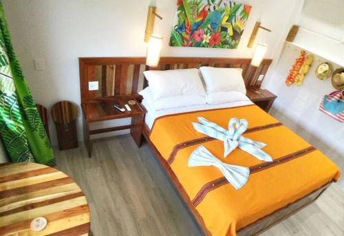 珀拉什奇亚The Tiki Toucan Tropical Suite + Private Pool的一间卧室配有带橙色床单和鲜花的床。