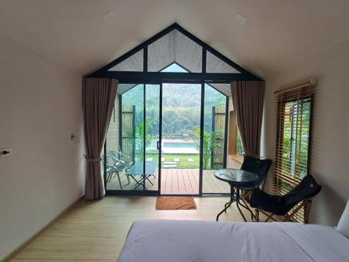 Tha KradanLake Hill Resort Kanchanaburi的一间卧室配有一张床,享有庭院的景色