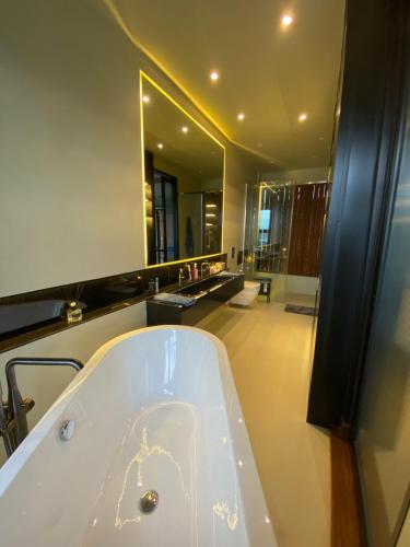 波德申Villa AZJA PD的一间带浴缸和大镜子的浴室