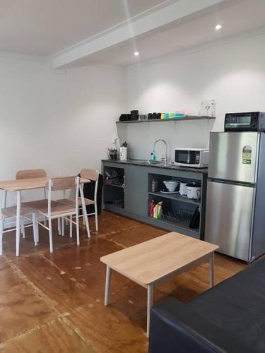 阿洛菲Kaina Kaute的厨房配有桌子和不锈钢冰箱。