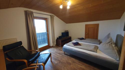 基姆湖畔布赖特布伦Chiemsee-Ferienhaus Schlegel的卧室配有床、椅子和窗户。