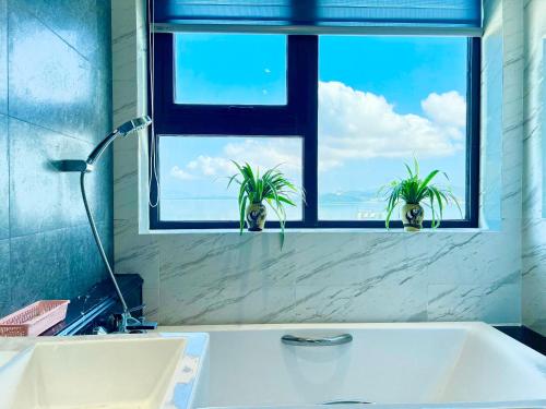 归仁ALTARA Quy Nhơn - RUBY Luxury Apartment的浴室设有两盆植物窗户