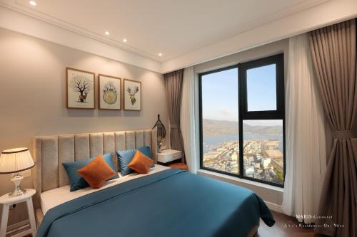 归仁ALTARA Quy Nhơn - RUBY Luxury Apartment的一间卧室设有蓝色的床和大窗户
