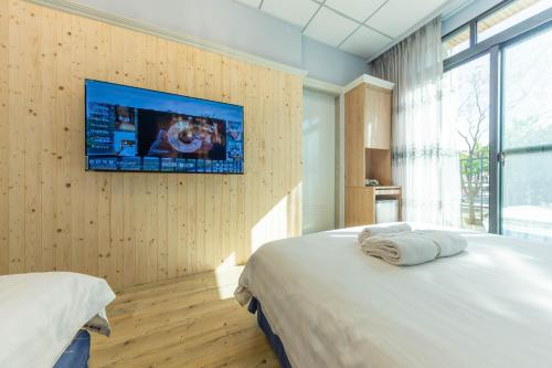 高雄自由宿-盐埕馆的一间卧室配有一张床,墙上配有电视