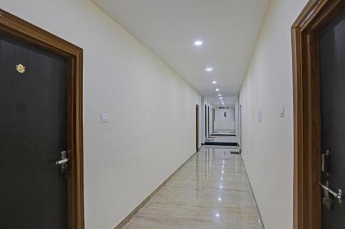 瓦拉纳西OYO Flagship J.d.p Guest House的一条带白色墙壁的走廊和一条带门的长走廊