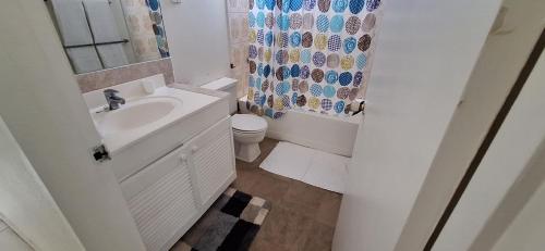 布里奇敦Seaview Property 3B Two Bedroom Apt Hasting Towers的浴室配有水槽、卫生间和浴帘
