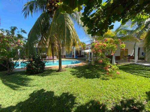 蒙特里科Casa de Descanso en Monterrico的一个带游泳池和棕榈树的庭院