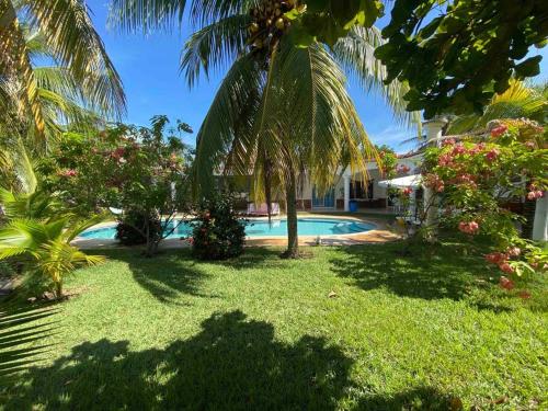 蒙特里科Casa de Descanso en Monterrico的一个带游泳池和棕榈树的度假村