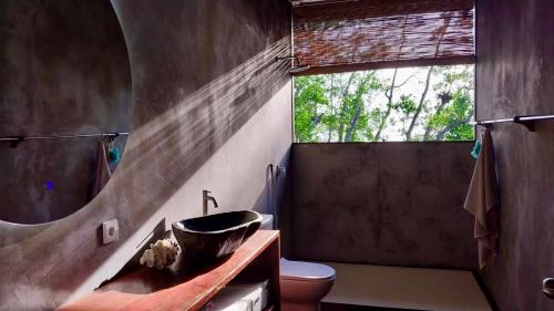 SaonekVilla Luzo的一间带水槽和卫生间的浴室以及窗户。