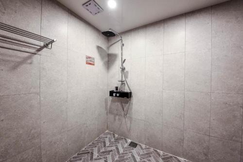 釜山Haute Hotel的一间铺有瓷砖地板的带淋浴的浴室