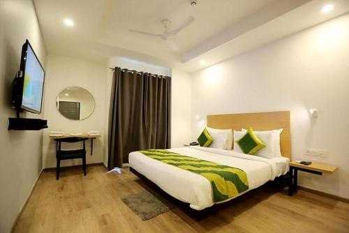 新德里Kastle Guest House的酒店客房设有一张大床和一张书桌。