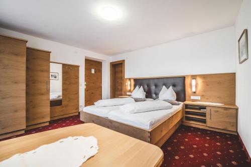 舍恩伯格松呐黒木膳食公寓酒店的一间卧室配有一张大床和木制橱柜。