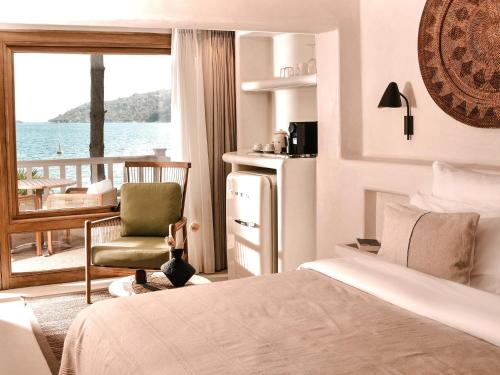 图兰克Perios Beach House - Adults Only的一间带一张床和一把椅子的卧室以及一个阳台