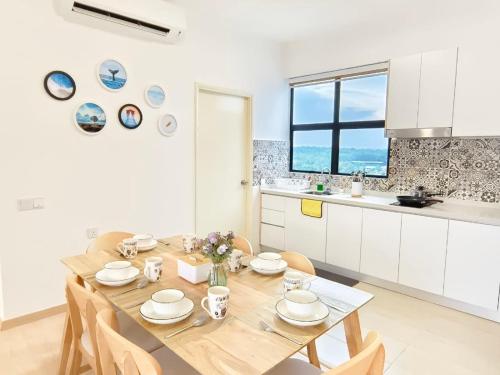 Tangga BatuMutiara Melaka Beach Resort by Glex的厨房以及带木桌和椅子的用餐室。