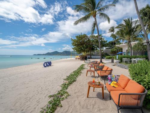 查汶苏梅岛遨舍查汶度假酒店的海滩上设有桌椅,大海上设有沙滩