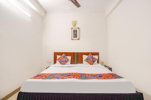 阿格拉FabHotel Sai Residency的一间卧室配有一张带白色床罩的大床