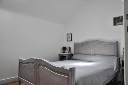 Gîte de France à Soudeilles épis - Gîte de France 574的一间卧室配有一张白色的木架床