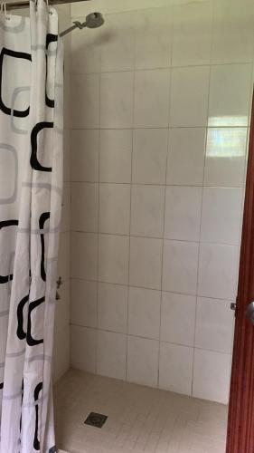 霍尼亚拉Canopy cottage的配有黑色和白色淋浴帘的淋浴