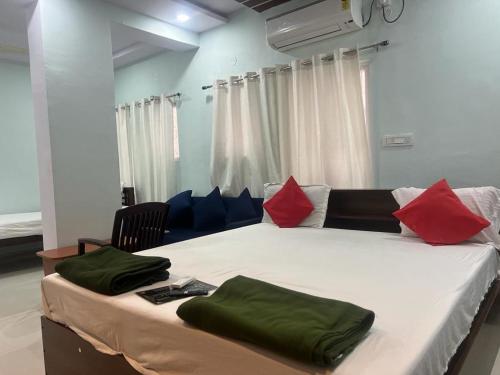 海得拉巴Brundavan的一间卧室配有一张带红色和蓝色枕头的大床