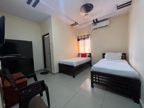 海得拉巴Brundavan的一间设有两张床和电视的房间