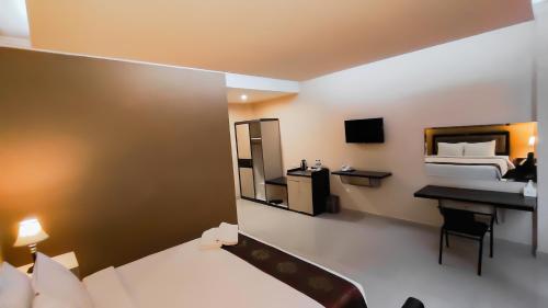SinabonoJTS Hotel的一间卧室配有一张床、一张书桌和一面镜子