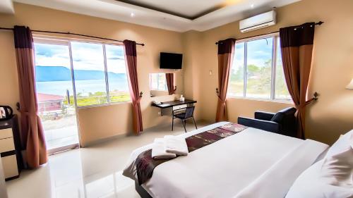 SinabonoJTS Hotel的卧室配有一张床、一张书桌和窗户。