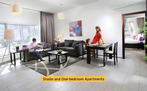 迪拜Citadines Metro Central Hotel Apartments的坐在客厅的男人和女人