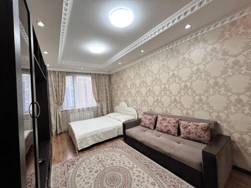 阿拉木图Apartmens in Complex Almaly 83-51的客厅配有沙发和1张床