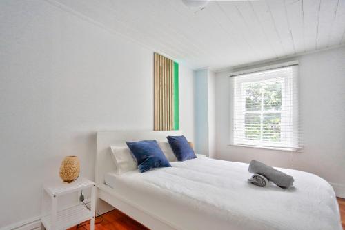 悉尼Family Friendly 3 Bedroom House Glebe 2 E-Bikes Included的白色卧室配有白色床和蓝色枕头