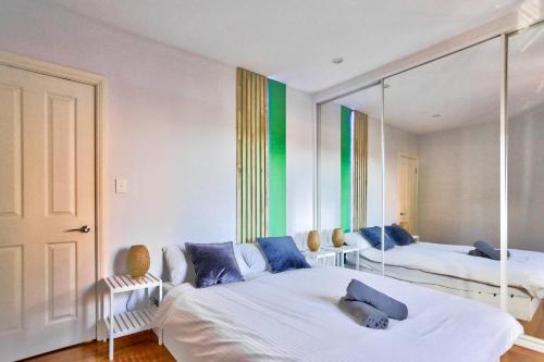悉尼Charming 2 Bedroom House Surry Hills的一间卧室配有两张床和镜子
