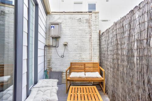 悉尼Charming 2 Bedroom House Surry Hills的坐在建筑物边的木凳