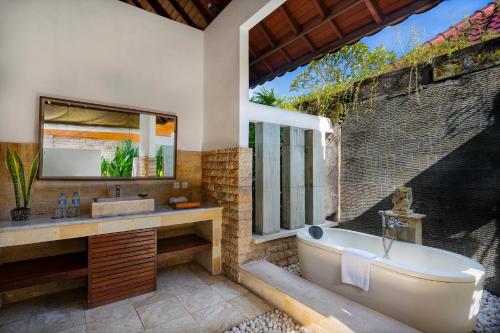 塞米亚克总理酒店集团巴厘岛总理别墅的带浴缸、水槽和窗户的浴室
