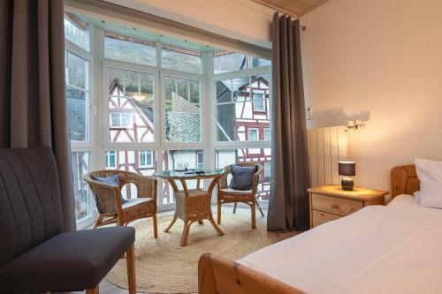 贝尔恩卡斯特尔-库斯Gästehaus "Ursula" Hotel Garni的一间卧室配有一张床、一张桌子和一个窗户。