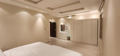 麦加شقة بثلاث غرف نوم وصالة的卧室设有白色的床和走廊