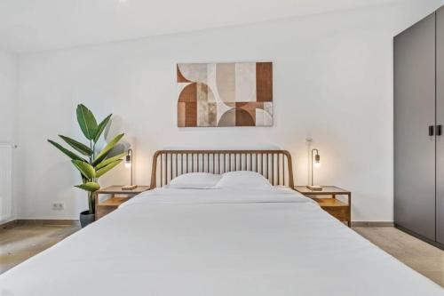 卢森堡Luxurious 2BR Apt with Balcony in Luxembourg的一间卧室配有一张带两盏灯的大型白色床。