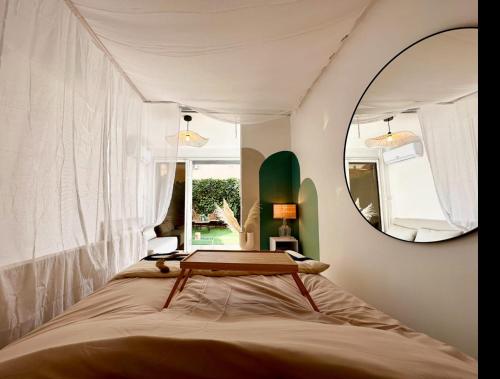 阿格德角Super Mini Loft avec Cinéma et Jardin - Cap d'Agde的一间卧室配有一张床和镜子