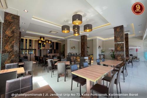坤甸G坤甸酒店的一间设有木桌和椅子的餐厅