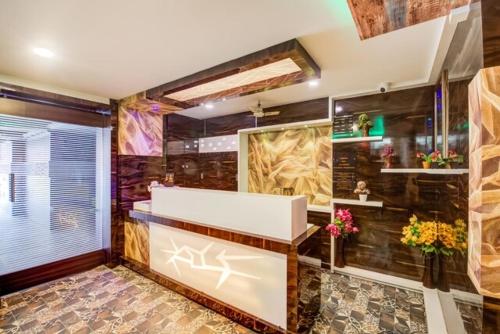 维杰亚瓦达HOTEL TEJASRI RESIDENCY的一间带木墙和白色浴缸的浴室