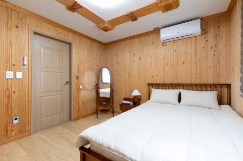 济州市Bijarim Healing Pension的一间卧室配有一张床、一扇门和一把椅子