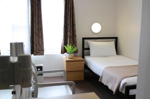 伦敦贵族酒店的小酒店客房设有两张床和一张桌子。