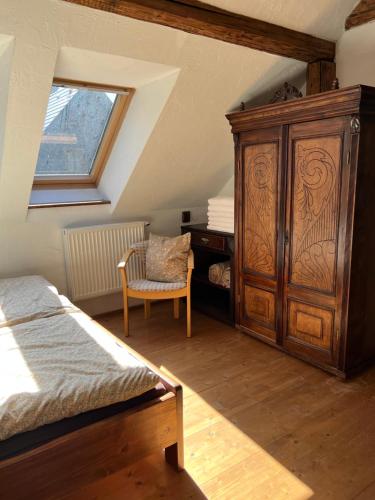维许纳波察folk cottage Vysna Boca的一间卧室配有大型木制橱柜和椅子
