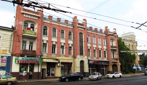 哈尔科夫Moskovs'kyi Avenue 41的一座大型红砖建筑,在街上停放汽车