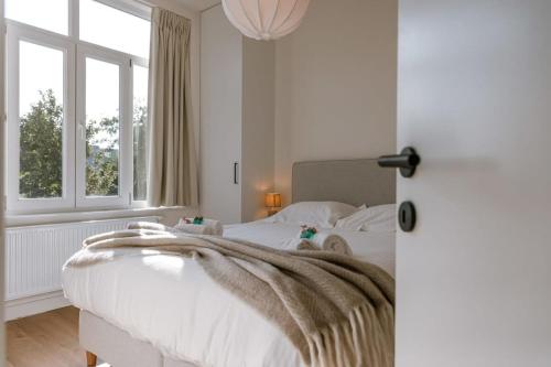 波佩林赫Beautiful vacation home 'Valkehuisje' in Poperinge的卧室配有一张白色的床,床上有毯子