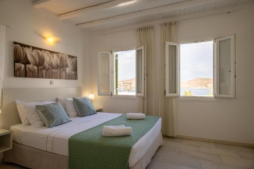 纳乌萨Anthos Apartments的一间卧室设有一张大床和两个窗户。