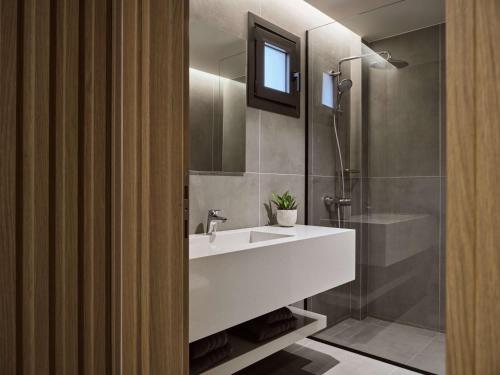 伊罗达Elounda Palm Hotel & Suites的浴室配有白色水槽和淋浴。